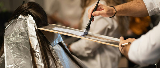 Coloriste appliquant une coloration professionnelle au pinceau dans un salon de coiffure