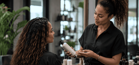 Coiffeuse conseillant une cliente sur l'entretien de ses cheveux après un diagnostic personnalisé.