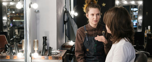 Diagnostic capillaire personnalisé réalisé par une coiffeuse professionnelle dans un salon de coiffure.